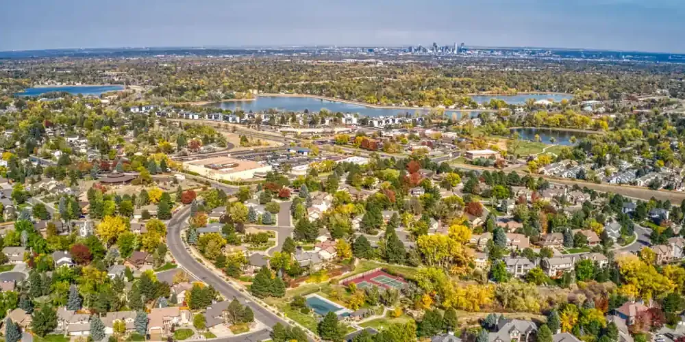 Denver suburban neighborhood with green lawns and Front Range mountains